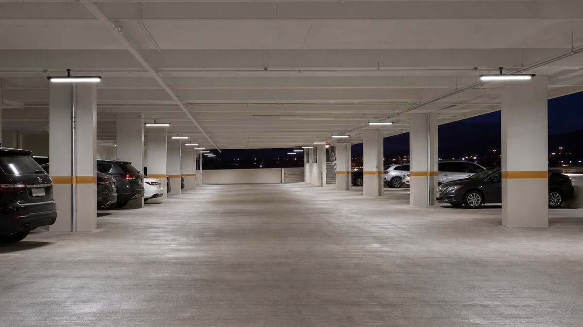 Covered parking garage level in Fort Worth with uniform LED garage fixtures between concrete columns